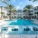 Large sparkling blue pool with a large pool deck and lounge chairs